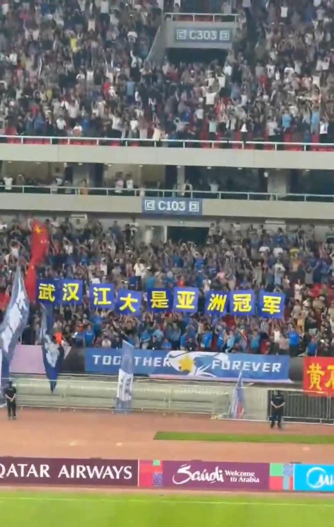 武汉女足夺得亚冠冠军，现场球迷打出武汉江大是亚洲冠军横幅